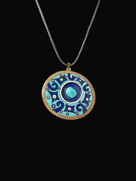 Decorative pendant necklace with blue and gold design on a black background